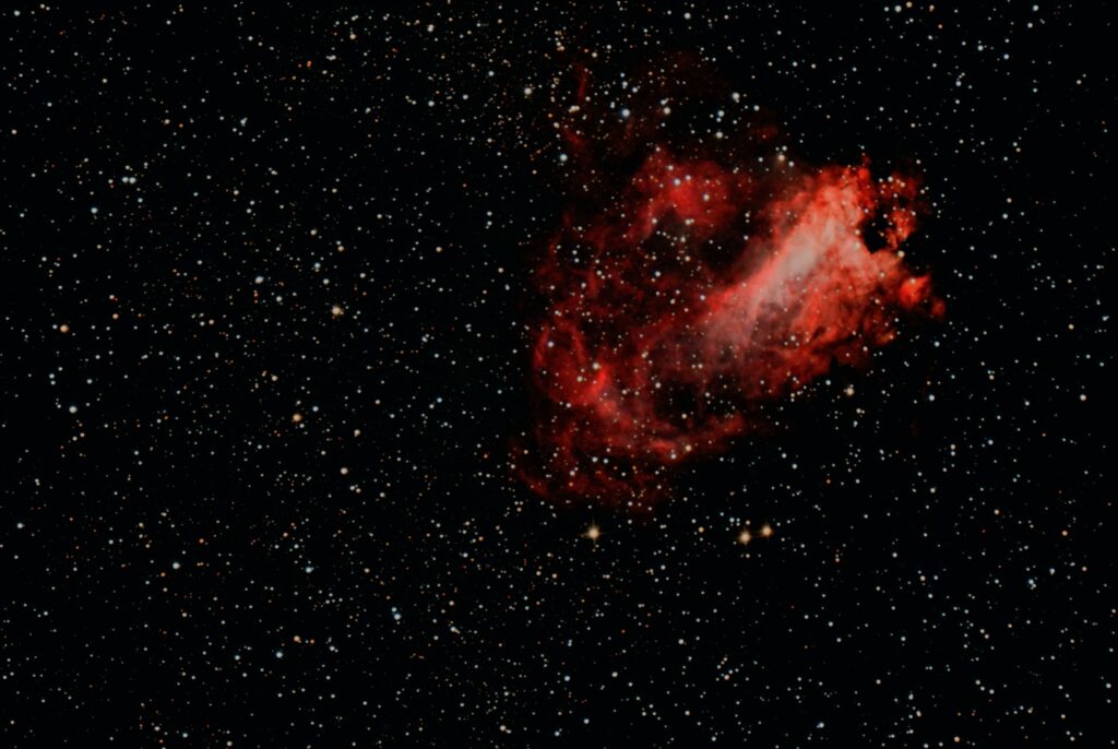Photographie astronomique de la nébuleuse M17, dite nébuleuse Oméga ou du Cygne, dans la constellation du Sagittaire. Elle a trouvé son nom au près de Charles Messier en 1764. Cette photographie de la nébuleuse M17, tintée de couleurs rouges et lumineuses, entourée un riche champ d'étoiles, a été prise par Laurent Benintende en août 2025. Matériel utilisé : Dobson 305/1500 Go To motorisé, équipé d’un correcteur de coma Maxfield, et d’une caméra Altair 26C connectée à un ordinateur qui réalise l’empilement des photos via le logiciel SharpCap.